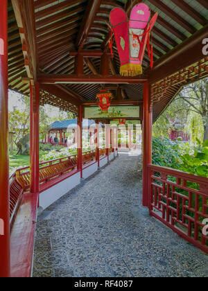 September 2018 - Hennegau, Belgien: Traditionelle chinesische Holz- Korridor in leuchtendem Rot mit Laternen in der Chinesische Garten im Zoo Pairi Daiza Stockfoto