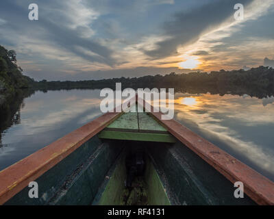 Paumari, Brasilien - 07. Dezember 2017: traditionelle, indische Boot und schöne Aussicht mit der Reflexion in der Lagune von Amazonas Dschungel. während des Sonnenuntergangs. Lat. Stockfoto