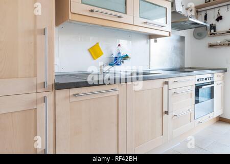 Ausgestattete Küche in einer Wohnung mit elektrischen Geräten und Arbeitsfläche, Schubladen und Wandschrank Stockfoto