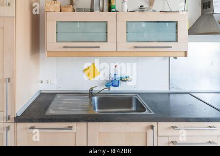 Ausgestattete Küche in einer Wohnung mit elektrischen Geräten und Arbeitsfläche, Schubladen und Wandschrank Stockfoto