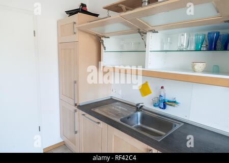 Ausgestattete Küche in einer Wohnung mit elektrischen Geräten und Arbeitsfläche, Schubladen und Wandschrank Stockfoto