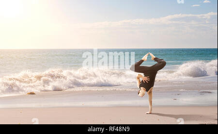 Erstaunlich yoga Mann sie einen Handstand outdoor. Mixed Media Stockfoto