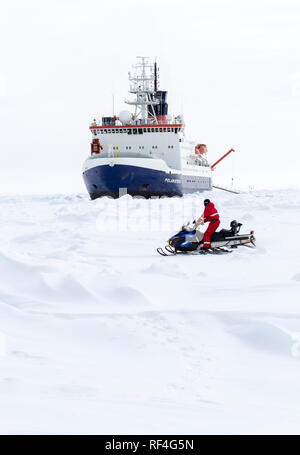 Weddell Meer, Antarktis - September 19, 2013: ein Wissenschaftler aus dem Forschungseisbrecher Polarstern zu einem Ice Camp reisen wird von einem Schneemobil über Stockfoto