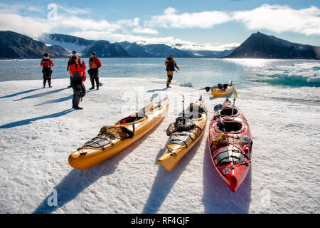 SVALBARD, Norwegen - Kajaktouristen erkunden das eisige Wasser und die unberührten Landschaften der Arktis rund um Svalbard. Diese einzigartige und abenteuerliche Form des Tourismus bietet ein Erlebnis aus nächster Nähe mit der arktischen Umgebung und zeigt die atemberaubende Schönheit und empfindliche Ökosysteme der Region. Stockfoto