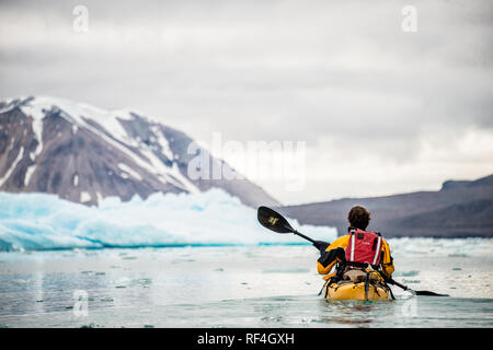 SVALBARD, Norwegen - Kajaktouristen erkunden das eisige Wasser und die unberührten Landschaften der Arktis rund um Svalbard. Diese einzigartige und abenteuerliche Form des Tourismus bietet ein Erlebnis aus nächster Nähe mit der arktischen Umgebung und zeigt die atemberaubende Schönheit und empfindliche Ökosysteme der Region. Stockfoto