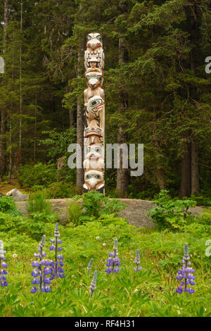 Native American Tlingit Indianer Totempfahl aus einem geschnitzten und bemalten Zedernholz in Bartlett Cove, Glacier Bay National Park, Alaska anmelden Stockfoto