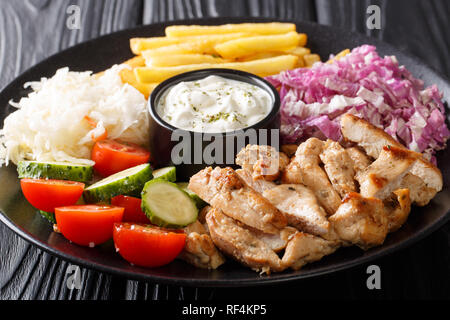 Köstliche shawarma Schüssel mit Hähnchen, Pommes frites, Gemüse und Sauce close-up auf einem Holztisch. Horizontale Stockfoto