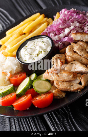 Chicken shawarma mit Gemüse und Sauce serviert auf einem Teller close-up auf dem Tisch. Vertikale Stockfoto