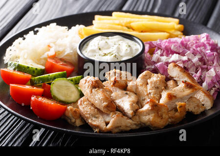 Chicken shawarma mit Gemüse und Sauce serviert auf einem Teller close-up auf dem Tisch. Horizontale Stockfoto