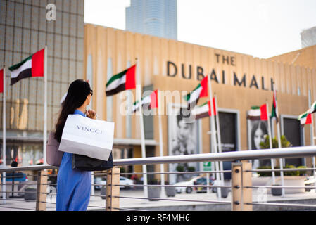 Dubai, Vereinigte Arabische Emirate - 26. März 2018: asiatische Touristen vor Dubai Mall Haupteingang mit Tüten Stockfoto