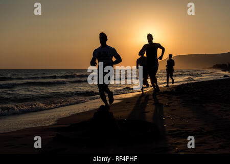 Menschen, die auf dem Strand am Morgen Stockfoto