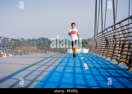 Mann laufen auf der Brücke an einem sonnigen Tag, Aktiv gesund Lifestyle Stockfoto