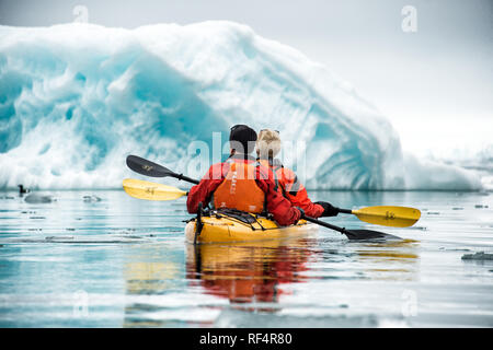 SVALBARD, Norwegen - Kajaktouristen erkunden das eisige Wasser und die unberührten Landschaften der Arktis rund um Svalbard. Diese einzigartige und abenteuerliche Form des Tourismus bietet ein Erlebnis aus nächster Nähe mit der arktischen Umgebung und zeigt die atemberaubende Schönheit und empfindliche Ökosysteme der Region. Stockfoto