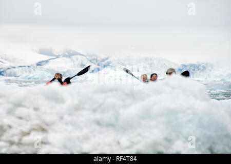 SVALBARD, Norwegen - Kajaktouristen erkunden das eisige Wasser und die unberührten Landschaften der Arktis rund um Svalbard. Diese einzigartige und abenteuerliche Form des Tourismus bietet ein Erlebnis aus nächster Nähe mit der arktischen Umgebung und zeigt die atemberaubende Schönheit und empfindliche Ökosysteme der Region. Stockfoto