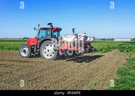 Bauer mit einem Traktor Sauen Mais auf seinem Feld. Stockfoto