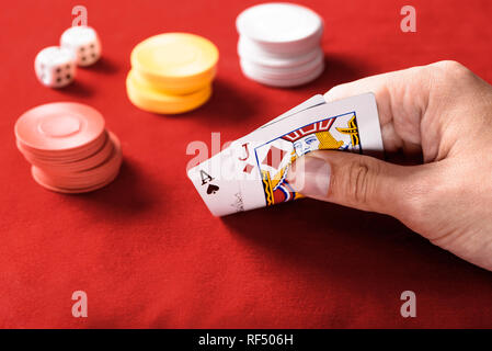 Selektiver Fokus der Mann hält Karten mit Chips und Würfel auf Hintergrund Stockfoto