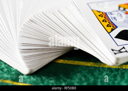 Selektiver Fokus der horizontal verteilt die Karten im Deck am grünen Tisch Stockfoto