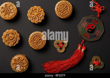 Blick von oben auf die Traditionelle mooncakes mit chinesischen Talismane isoliert auf Schwarz Stockfoto