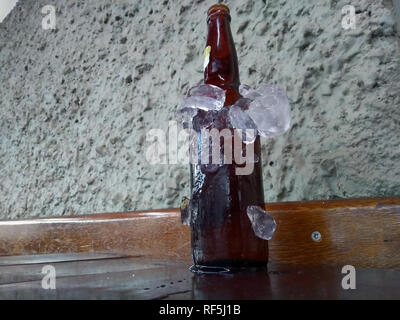 Bierflaschen in Eis gekühlt. Die eisigen Flasche Bier auf Wand Hintergrund. Stockfoto