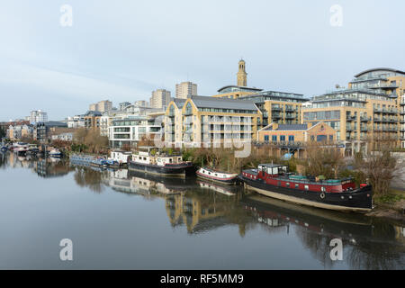 Hausboote auf der Themse mit dem neuen Kew Bridge Road, das Entwicklung in den Vordergrund und Brentford Türme Wohnsiedlung im Hintergrund Stockfoto