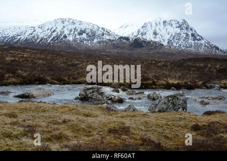 Der Fluss Etive mit den schneebedeckten Gipfeln der Schottischen Highlands im Hintergrund, Glencoe, Schottland, Vereinigtes Königreich. Stockfoto