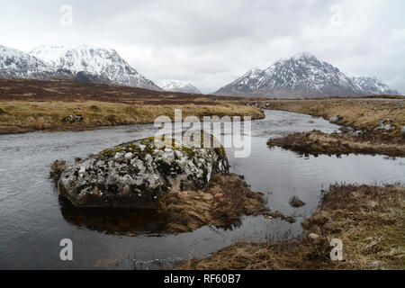 Der Fluss Buachaille Etive mit Etive Mor und schneebedeckten Gipfeln der Schottischen Highlands im Hintergrund, Glencoe, Schottland, Vereinigtes Königreich. Stockfoto