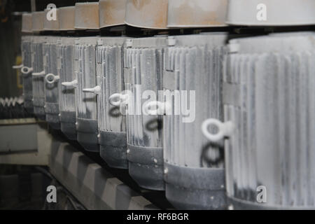 Eine Gruppe von mächtigen Elektromotoren. Elektrischer Antrieb von Industrieanlagen. Abstrakte industriellen Hintergrund. Staubige Elektromotoren in der Produktion. Weich Stockfoto