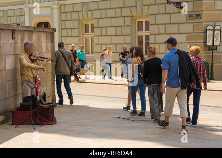 Krakau, Polen - 13. Juli 2018. Ein strassenmusikant spielt die Geige für Touristen auf einer Ecke des histroic Ulica Grodzka Straße in der Altstadt von Krakau Stockfoto
