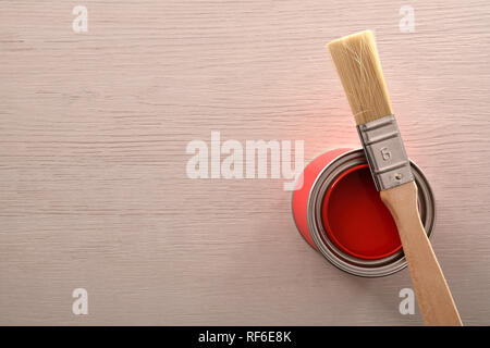 Kann mit roter Farbe mit Pinsel über auf einen hölzernen Tisch geöffnet. Ansicht von oben. Horizontale Komposition. Stockfoto