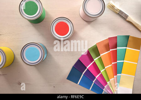 Farbige Lacke und Farben auf weißem Tabelle für die Renovierung der Materialien. Ansicht von oben. Horizontale Komposition. Stockfoto