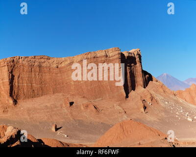 Die unglaublichen roten Felsen des Mondes Tal (Valle de la Luna) in der Nähe von San Pedro de Atacama bei Sonnenuntergang, mit anden Vulkan Licancabur in der Ferne. An Stockfoto