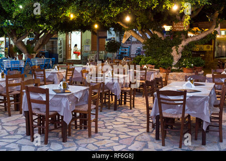 Chalki Insel, Griechenland - 27. August 2018. Traditionelle griechische Restaurants, Tischen und Stühlen warten auf Kunden in der Nacht. Chalki ist die kleinste Inh Stockfoto