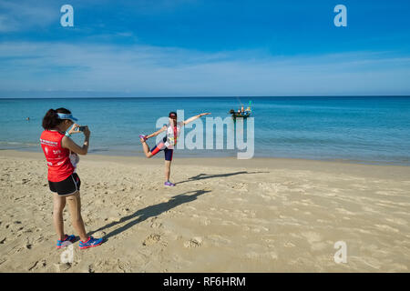 Eine junge weibliche Thailändische Touristen für ein Foto am Strand von Karon, Phuket, Thailand posing Stockfoto