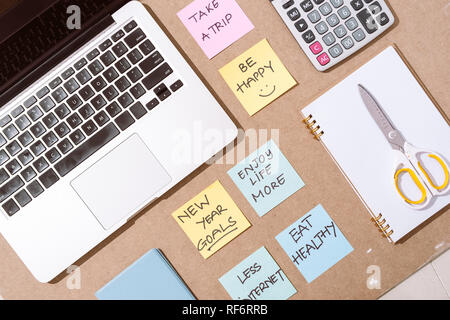 Farbiges Papier, Aufkleber mit Business Strategie und Laptop auf der Tischplatte Stockfoto