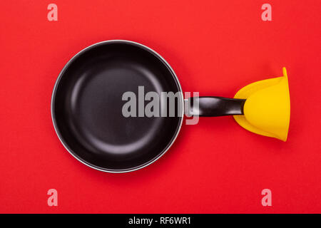 Pfanne mit Ofen Mitt auf rotem Hintergrund isoliert Stockfoto