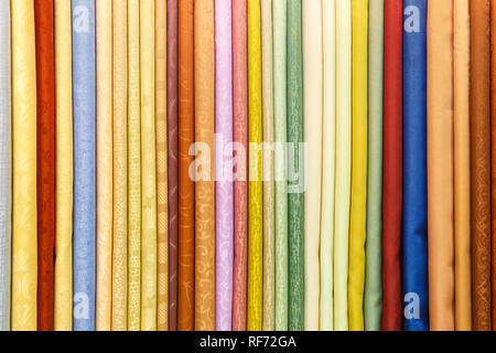 Große Auswahl an verschiedenen Farben textil Seide Kleidung lag in Zeile in Gardinen store Stockfoto