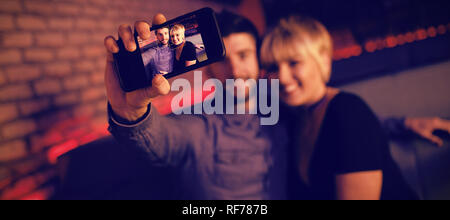 Paar unter selfie auf Handy in bar Stockfoto