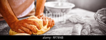 Den mittleren Abschnitt der Bäcker kneten den Teig Stockfoto