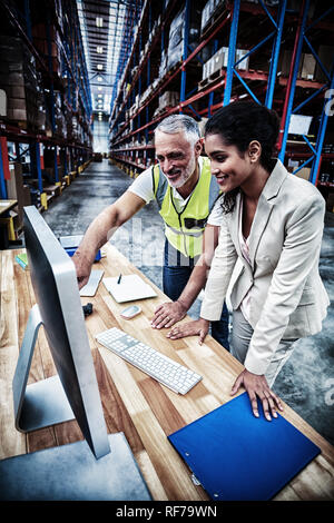 Worker Team ist auf der Suche nach einem Computer und lächelnd Stockfoto