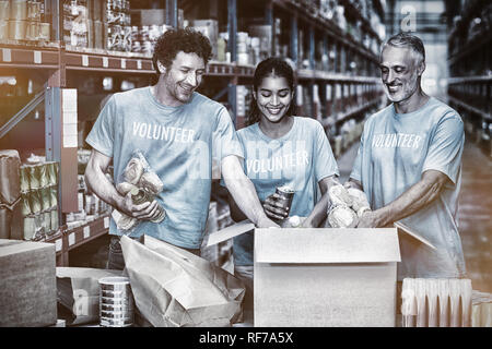 Glücklich freiwillige Aufräumen einige Güter in Karton Stockfoto
