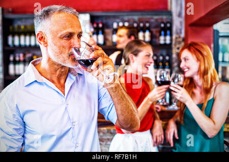 Menschen trinken Rotwein während zwei Freunde Toasten die Gläser im Hintergrund Stockfoto