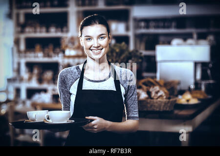 Porträt der Kellnerin hält Tablett mit Kaffeetassen Stockfoto