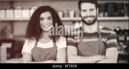 Porträt von lächelnden Kellner und Kellnerin stehen am Schalter Stockfoto