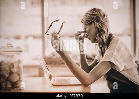 Bedienung am Tisch sitzen und mit Laptop in cafÃƒÂ© Stockfoto