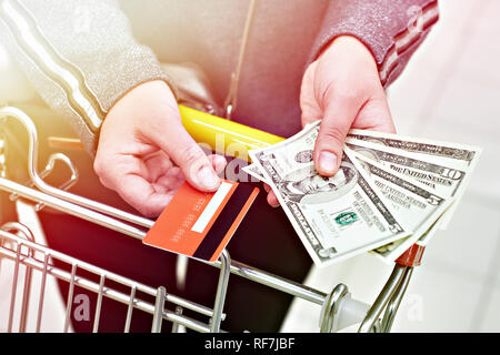 Bank Card und Dollarscheine in der Käufer Hand in den Store Stockfoto