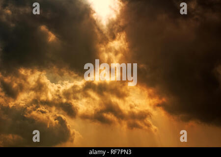 Sonne scheint durch dunkle Wolken. Dramatisches und apokalyptisches Himmelskonzept. Gewitterwolken Hintergrund - Explosionswolken Konzept. Stockfoto