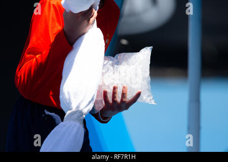 Eine ballkid halten sie eine Tüte voller Eiswürfel und ein Spieler Hals Handtuch Stockfoto