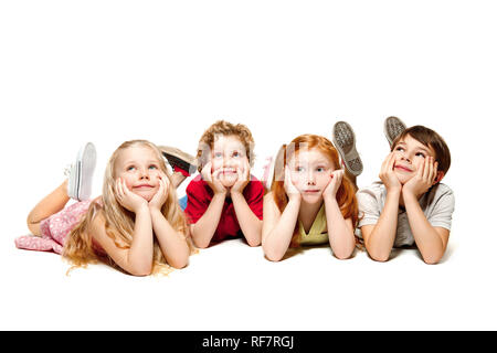 Nahaufnahme der glückliche Kinder liegen auf dem Boden im Studio und suchen, auf weißem Hintergrund. Kinder Emotionen, Tag des Buches, Bildung, Schule, Kind, Wissen, Kindheit, Freundschaft, Studie Konzept Stockfoto