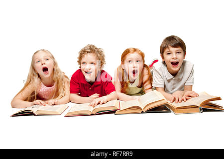 Der überraschte Kinder Jungen und Mädchen Verlegung mit Büchern im Studio, Lächeln, Lachen, auf weissem isoliert. Tag des Buches, Bildung, Schule, Kind, Wissen, Kindheit, Freundschaft, Studie Kinder Konzept Stockfoto