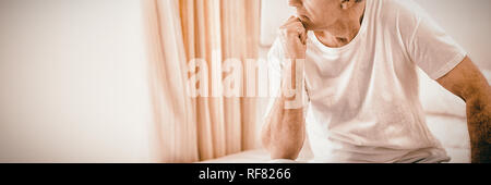 Besorgt senior Mann sitzt auf Bett Stockfoto